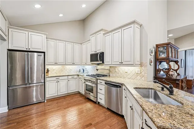 a kitchen with white cabinets sink and stainless steel appliances