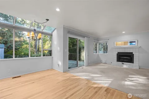 a view of an empty room with a fireplace and a window