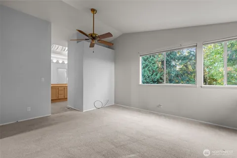 an empty room with windows and fan