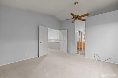a view of a room with a ceiling fan and entryway