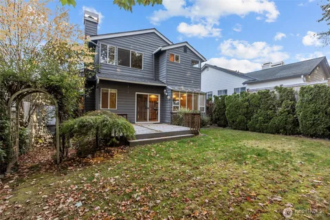 an aerial view of a house with a yard and a large tree