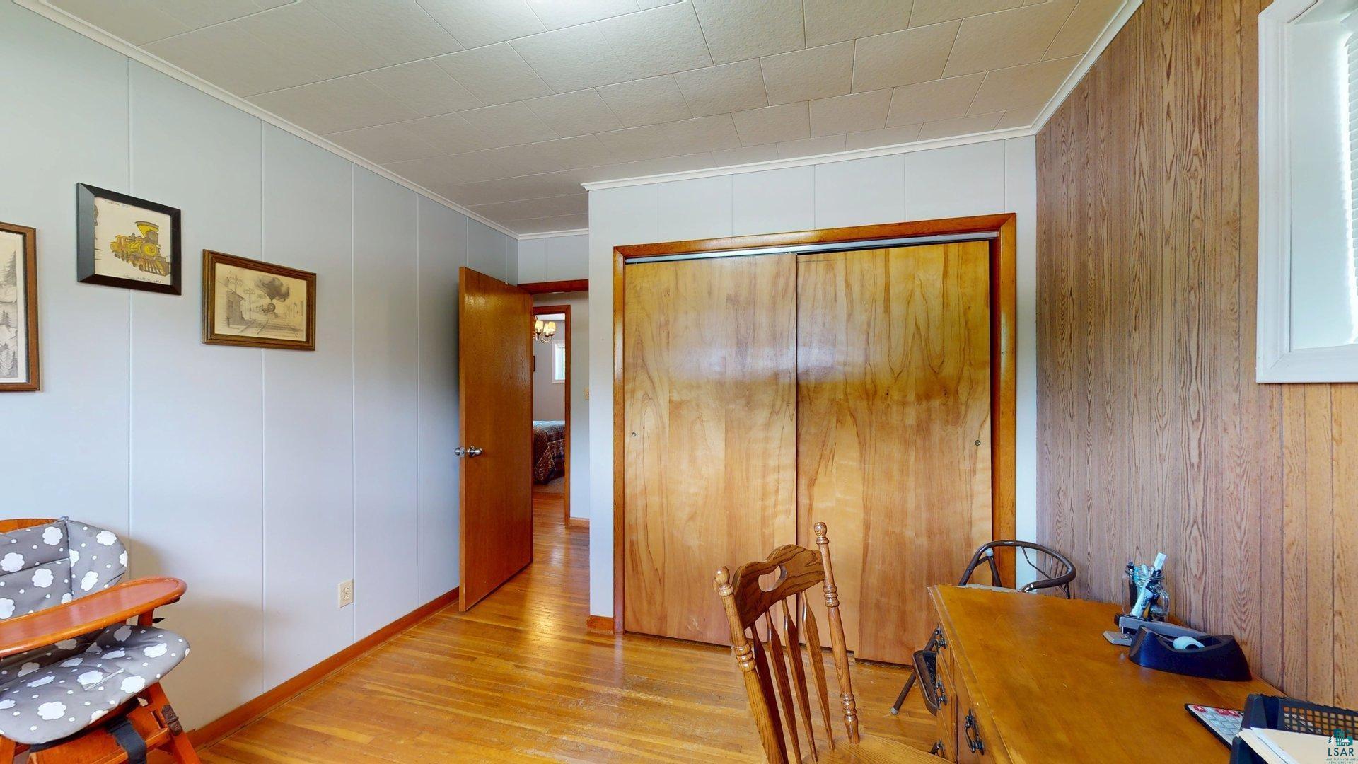 10614 Moose Lake Road Orr, MN 55771 - Photo 24 of 44 Interior room featuring wood-finish flooring, light blue paneling on one wall, and wood paneling on another