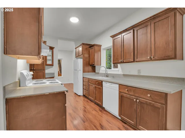 a kitchen with kitchen island granite countertop wooden cabinets a sink and dishwasher