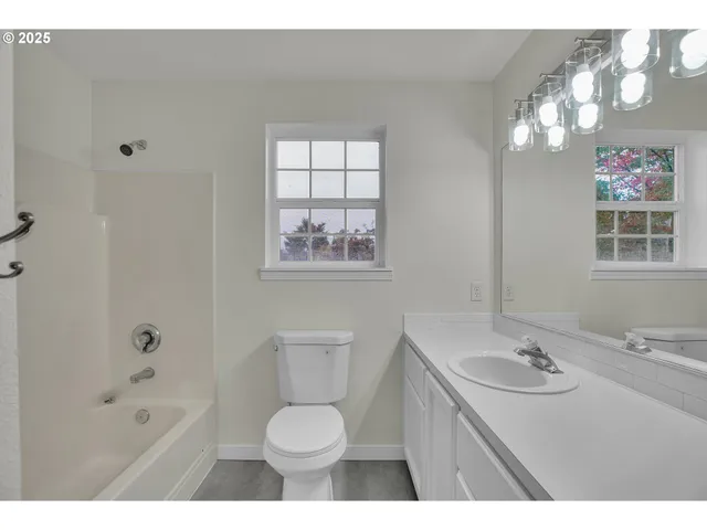 a bathroom with a sink a toilet a shower and a mirror