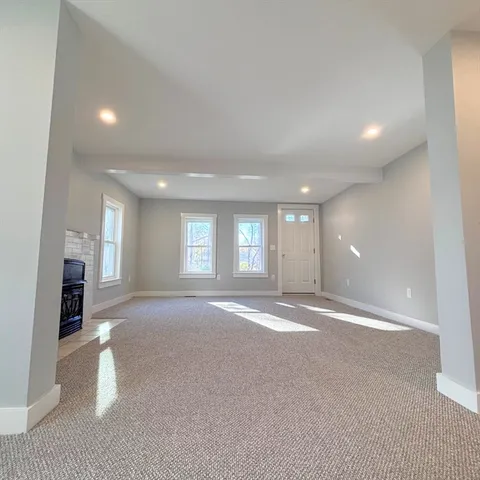 a view of an empty room and a kitchen
