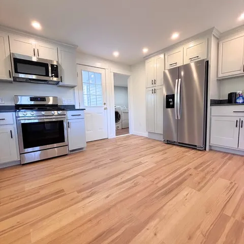 a kitchen with stainless steel appliances a stove microwave and refrigerator
