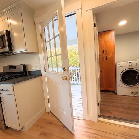 a view of a storage and utility room with wooden floor