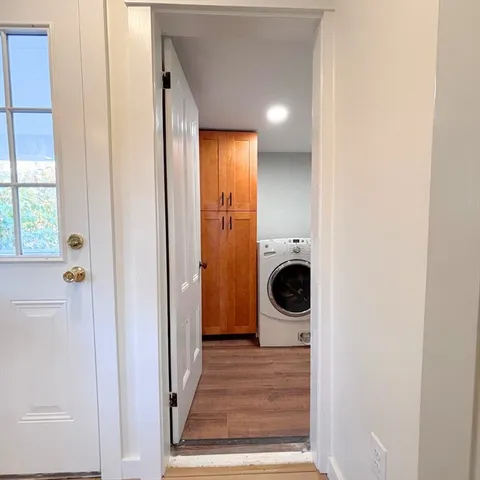 a view of a hallway with wooden floor and closet