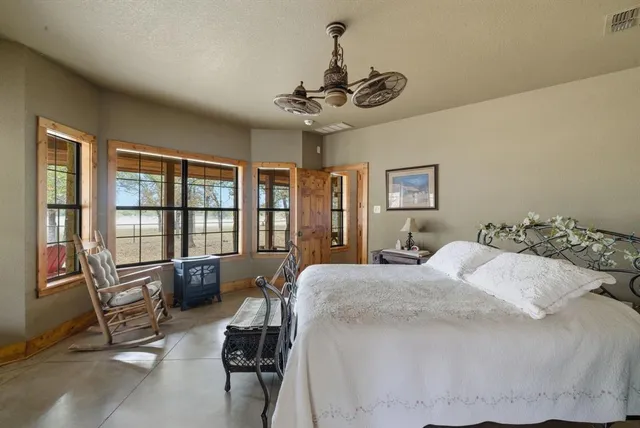 a bedroom with a bed couch and a large window