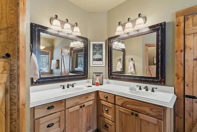 a bathroom with double vanity sinks a vanity and a mirror
