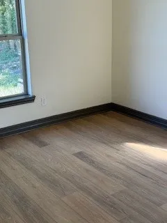 a view of a room with wooden floor and window