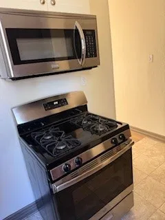 a stove top oven sitting inside of a kitchen