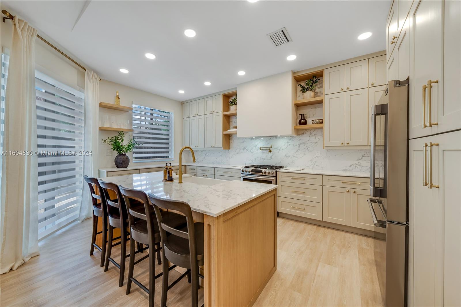 16429 Southwest 54th Terrace Miami, FL 33185 - Photo 9 of 28 a kitchen with stainless steel appliances granite countertop a kitchen island a stove a table and chairs in it