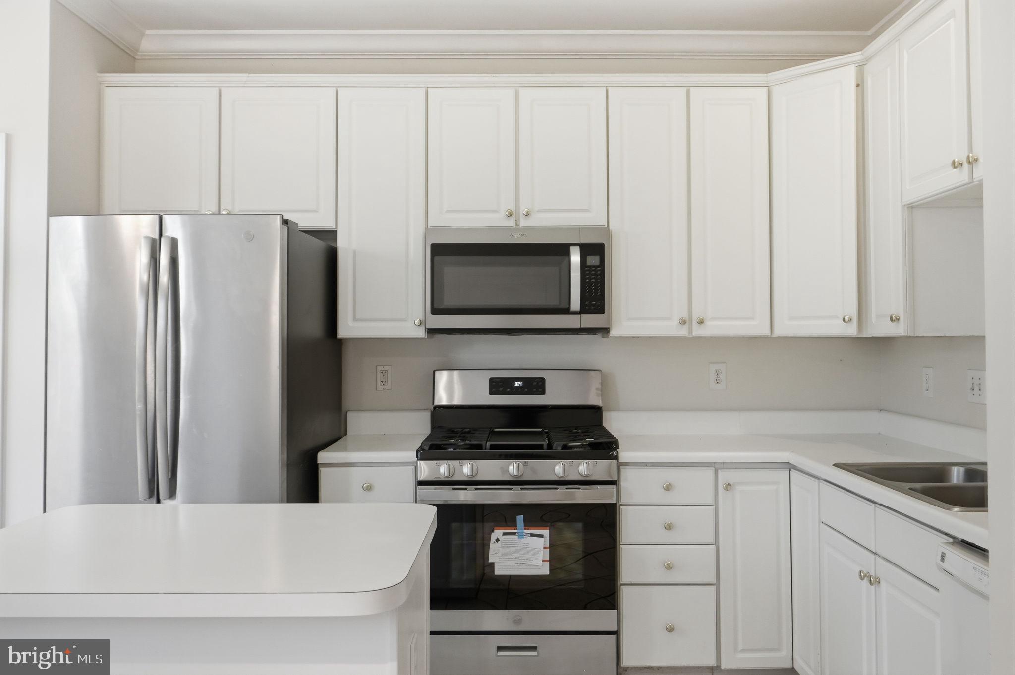 9702 Athletic Way Gaithersburg, MD 20878 - Photo 16 of 29 a kitchen with granite countertop white cabinets and stainless steel appliances