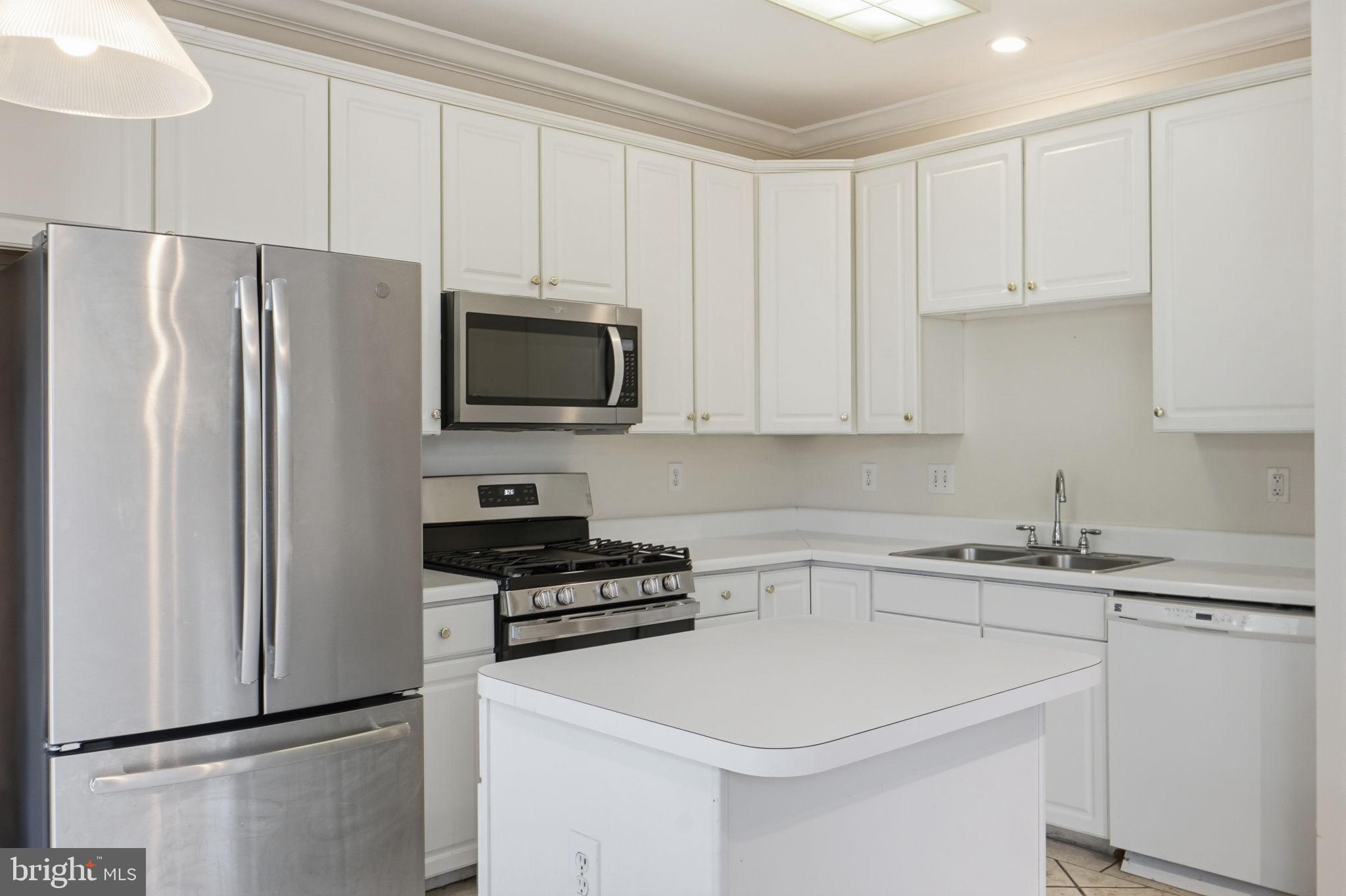 9702 Athletic Way Gaithersburg, MD 20878 - Photo 17 of 29 a kitchen with a refrigerator sink and cabinets