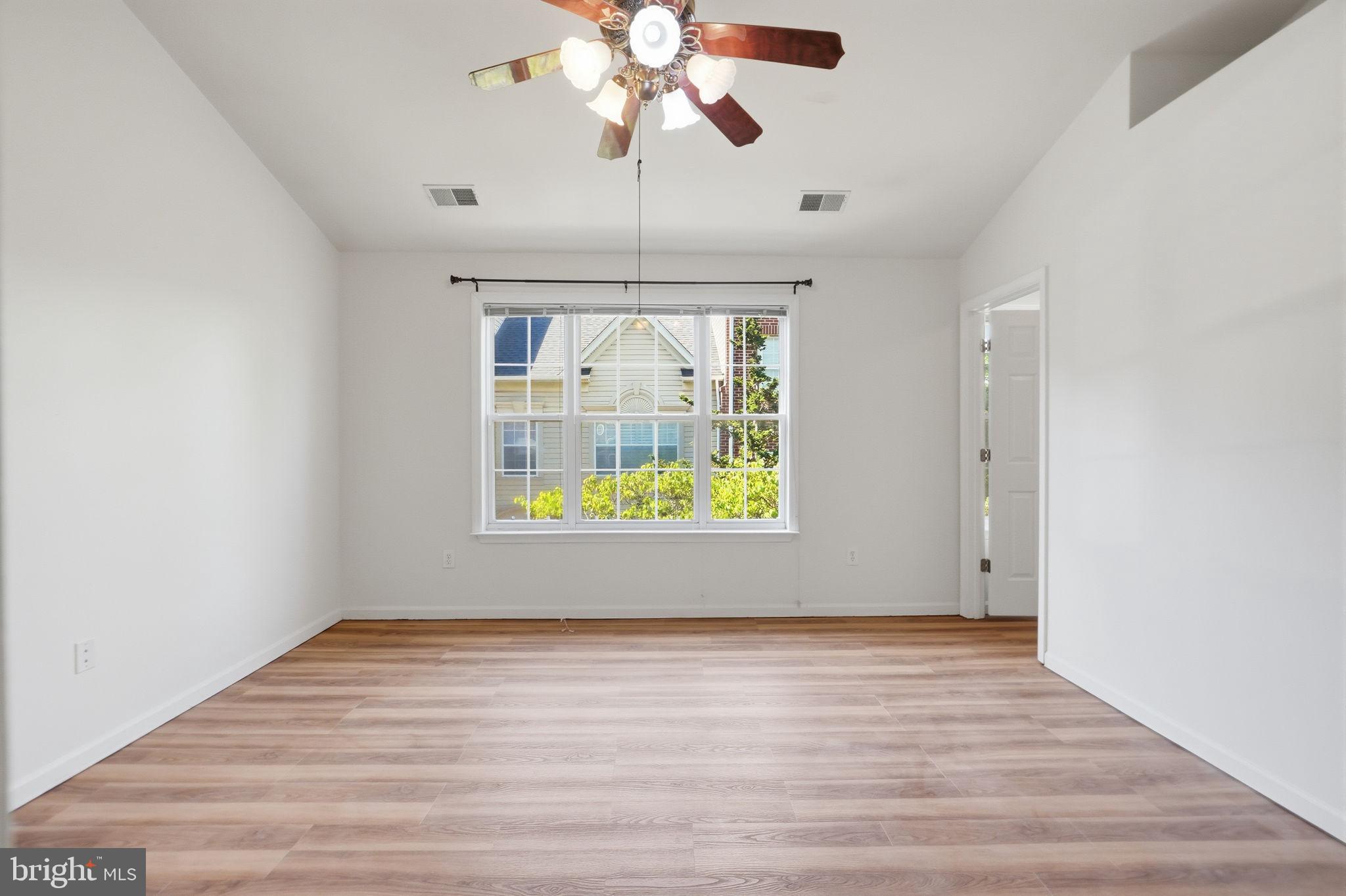 9702 Athletic Way Gaithersburg, MD 20878 - Photo 21 of 29 an empty room with wooden floor chandelier and windows