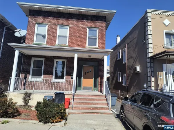 a view of a house with a car park side of road