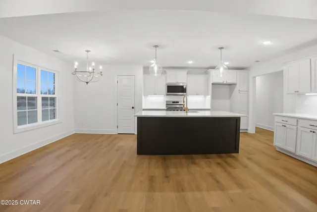 a kitchen with a stove and a wooden floor