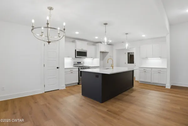 a kitchen with kitchen island a sink stainless steel appliances and cabinets
