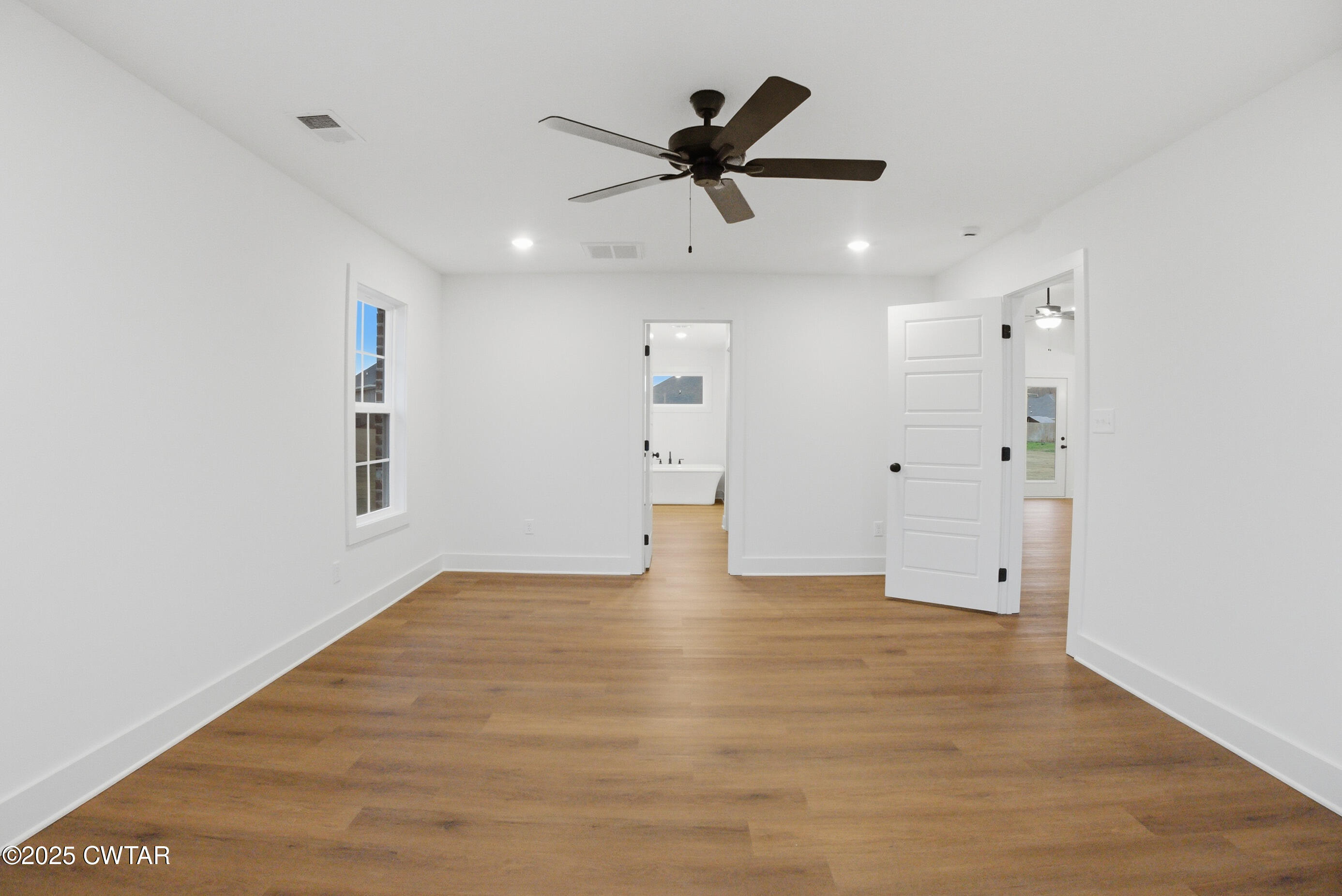 164 Daybreak Loop Medina, TN 38355 - Photo 21 of 40 a view of an empty room with wooden floor and a ceiling fan