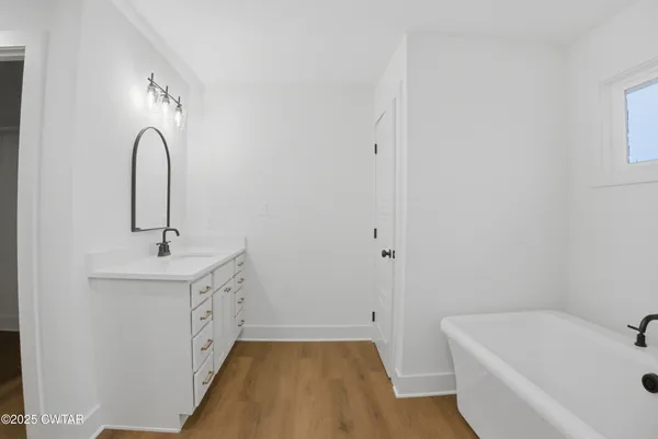 an empty room with a window and a ceiling fan