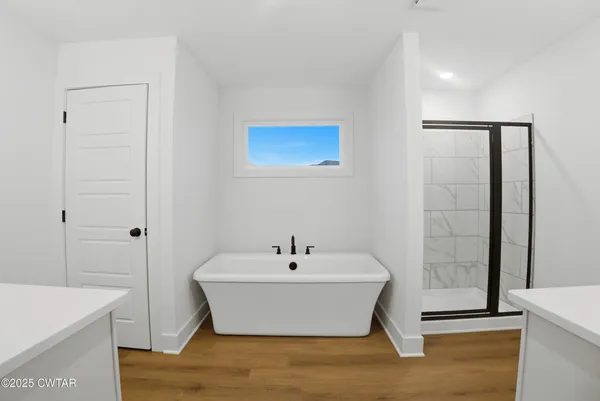 an empty room with a window and a ceiling fan