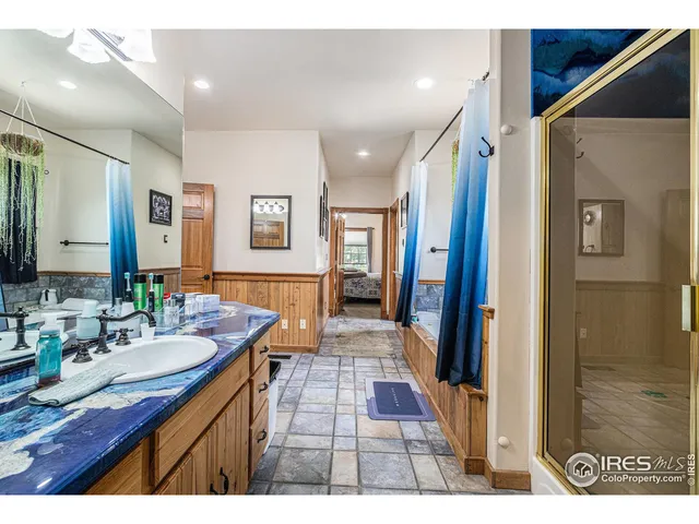 a bathroom with a sink double vanity granite tub shower and a mirror