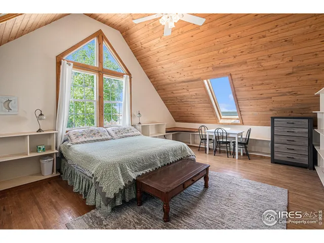 a bedroom with a bed a chair and a large window