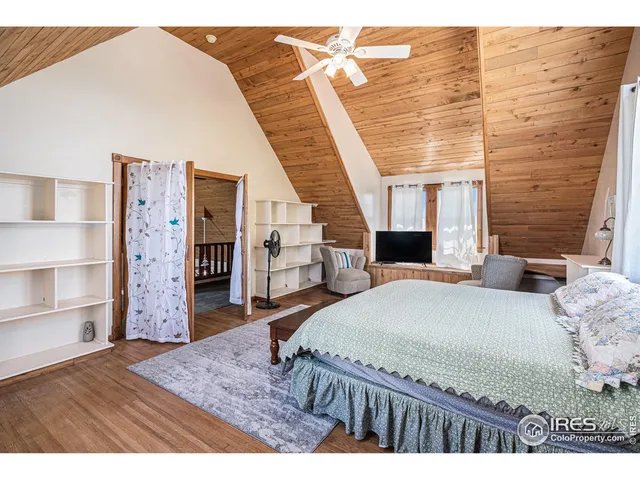 a bedroom with a bed closet and wooden floor