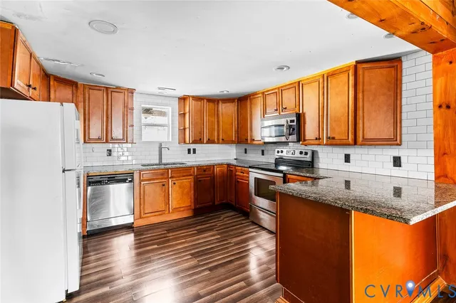 a kitchen with stainless steel appliances granite countertop a sink stove and refrigerator