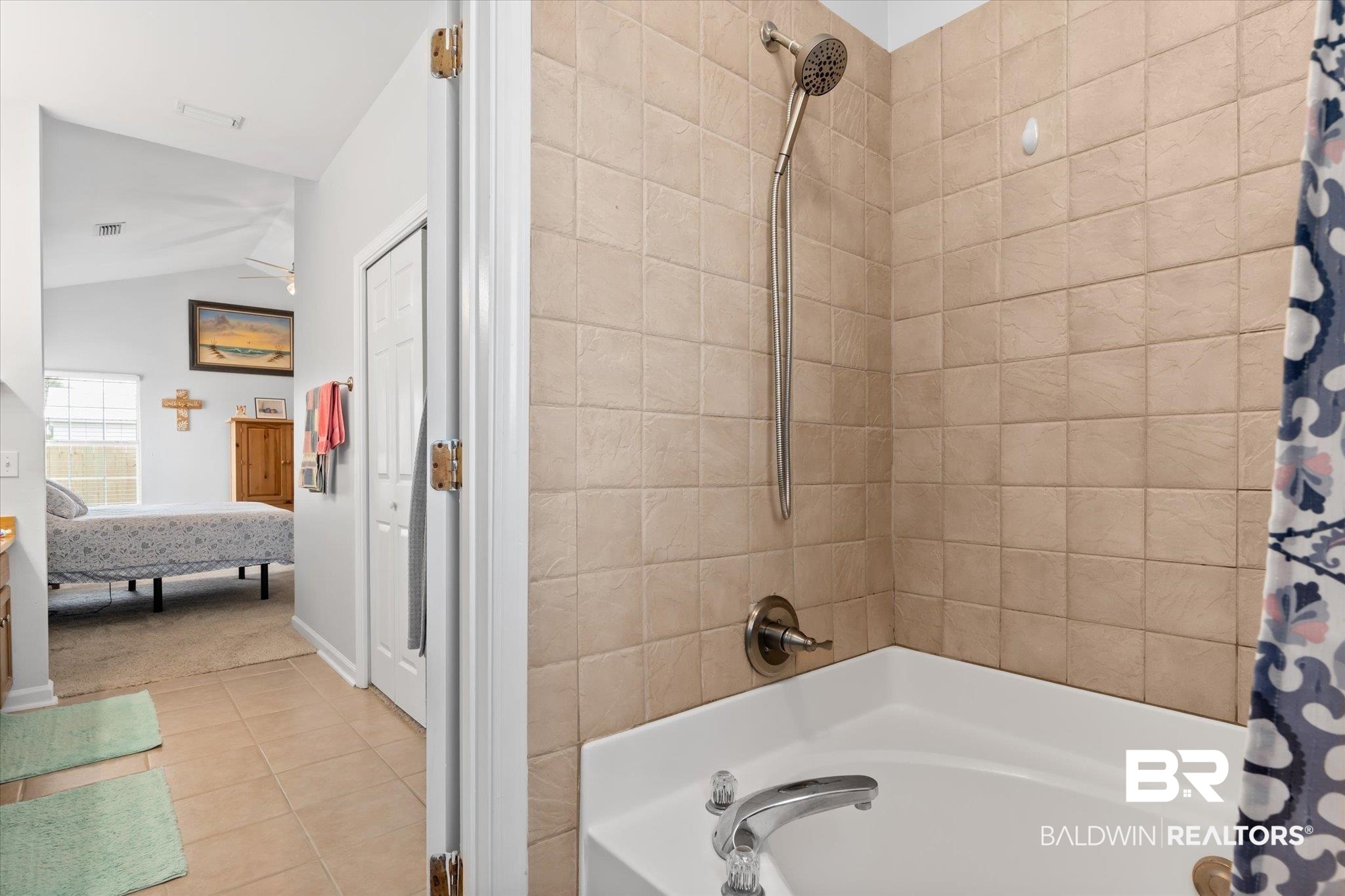 3876 Emerille Drive Foley, AL 36535 - Photo 17 of 31 Bathroom featuring shower / bath combo with shower curtain, tile patterned floors, and vaulted ceiling