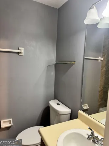 a white toilet sitting next to a bathroom sink and a shower