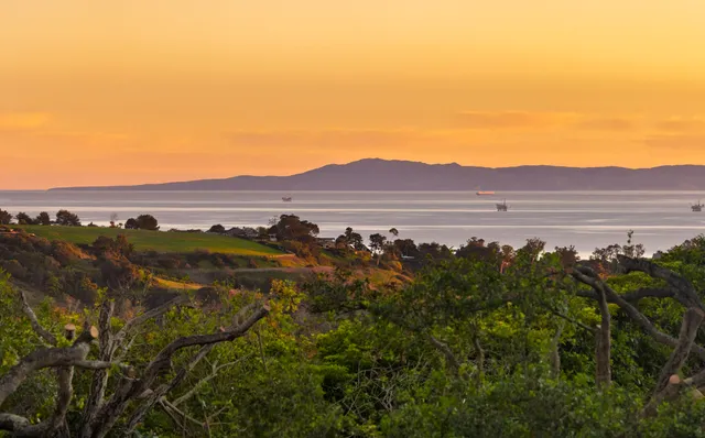 a view of a large mountain with green field in front of it