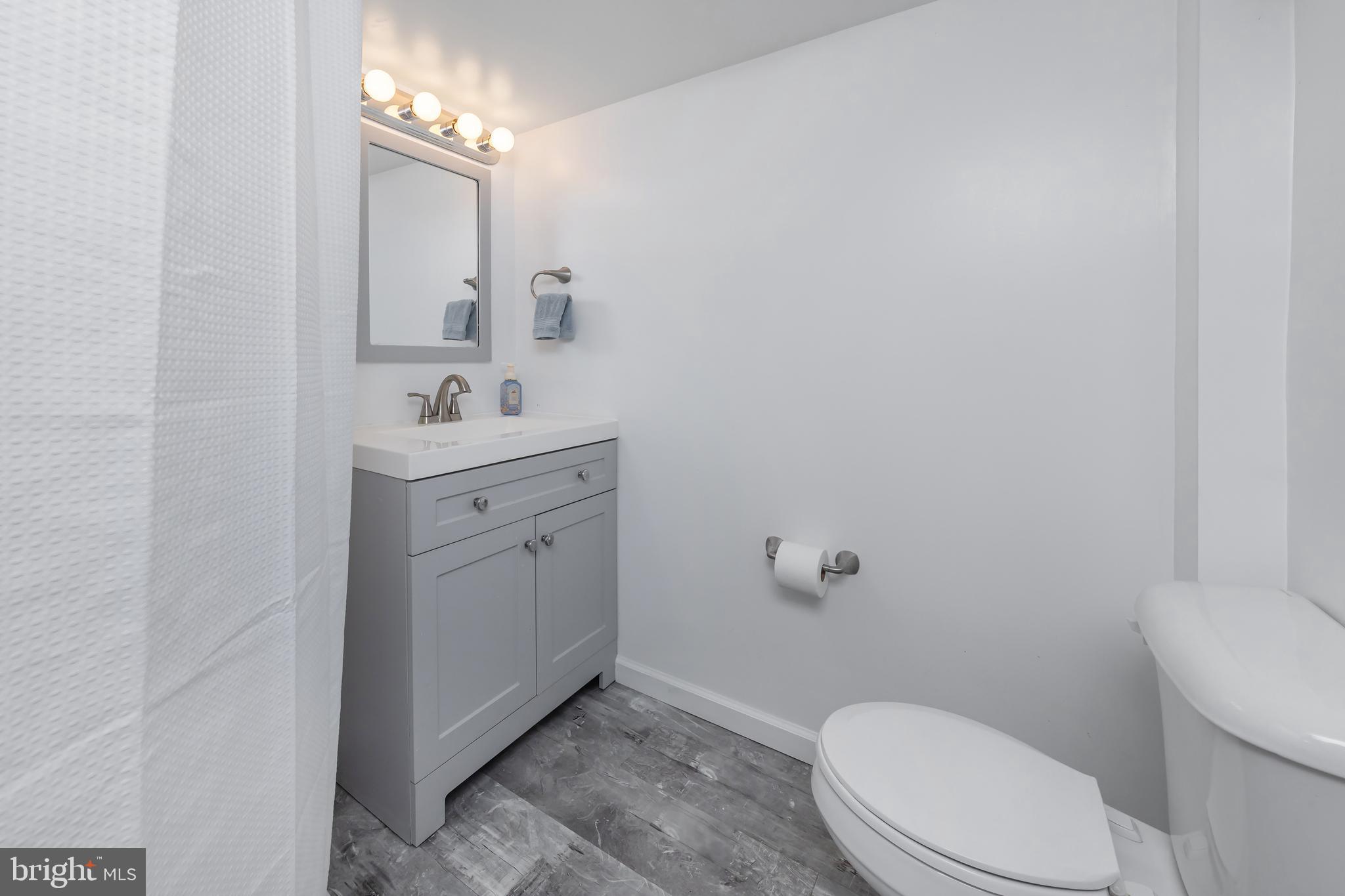 303 Main Street Mantua, NJ 08051 - Photo 28 of 50 a bathroom with a toilet a sink and mirror