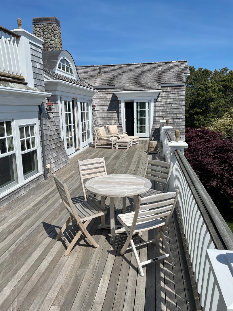 3 Katama Bay View Road Edgartown, MA 02539 - Photo 16 of 50 a view of a patio with table and chairs with wooden floor and fence