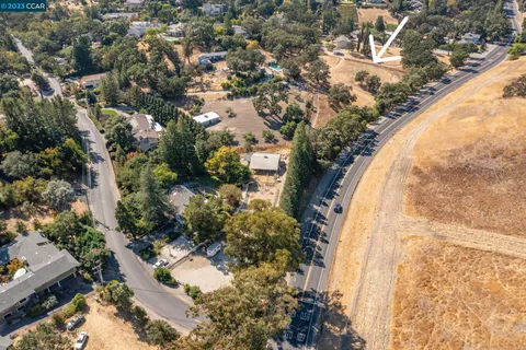 an aerial view of a house with a yard and large trees