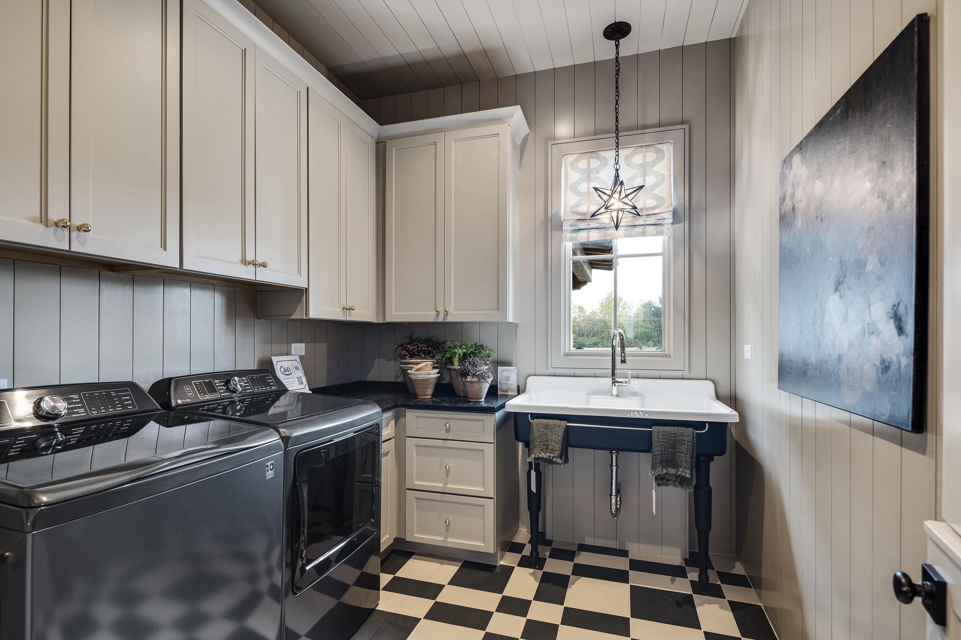 3310 Hidden Creek Loop Collierville, TN 38017 - Photo 15 of 40 Laundry room with wooden walls, dark flooring, independent washer and dryer, a chandelier, and cabinet space