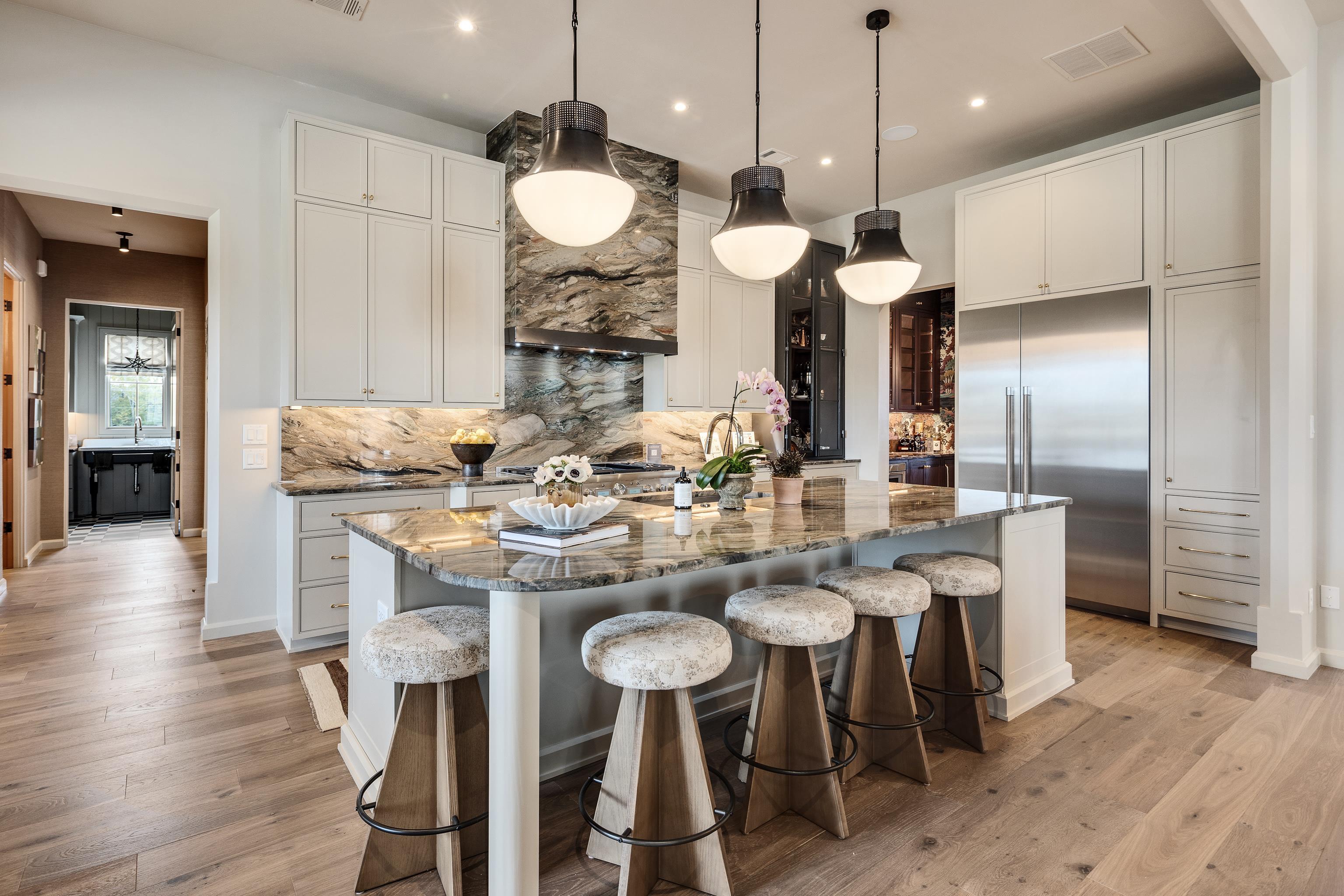 3310 Hidden Creek Loop Collierville, TN 38017 - Photo 8 of 40 Kitchen with a kitchen bar, a kitchen island with sink, dark stone countertops, decorative light fixtures, and backsplash