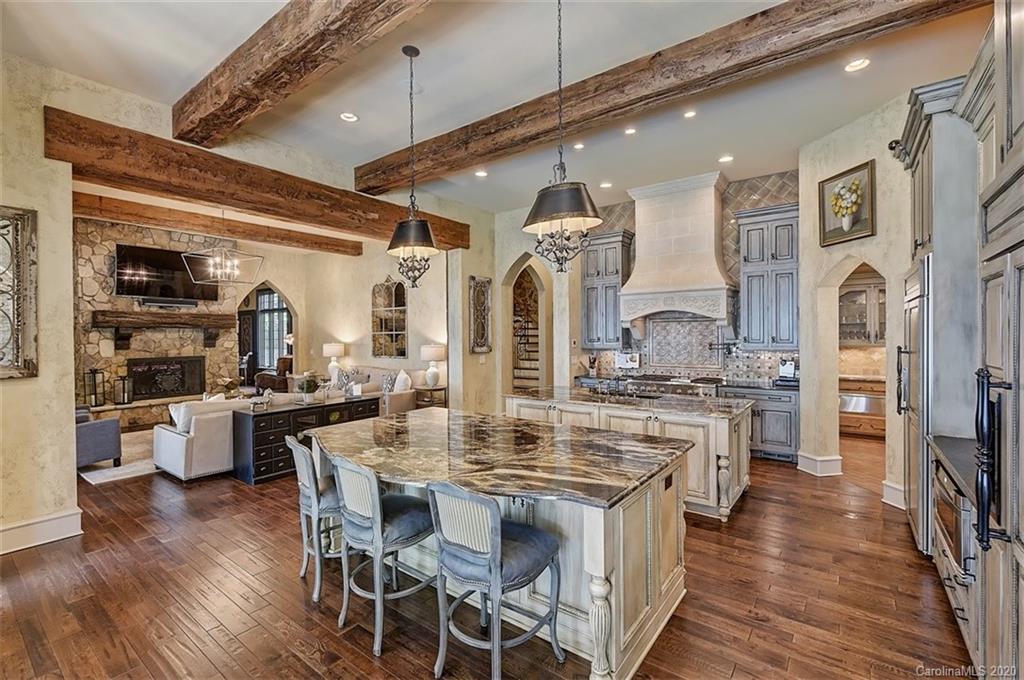 16505 Jetton Road Cornelius, NC 28031 - Photo 15 of 48 a kitchen with stainless steel appliances kitchen island granite countertop a stove a sink dishwasher and white cabinets with wooden floor