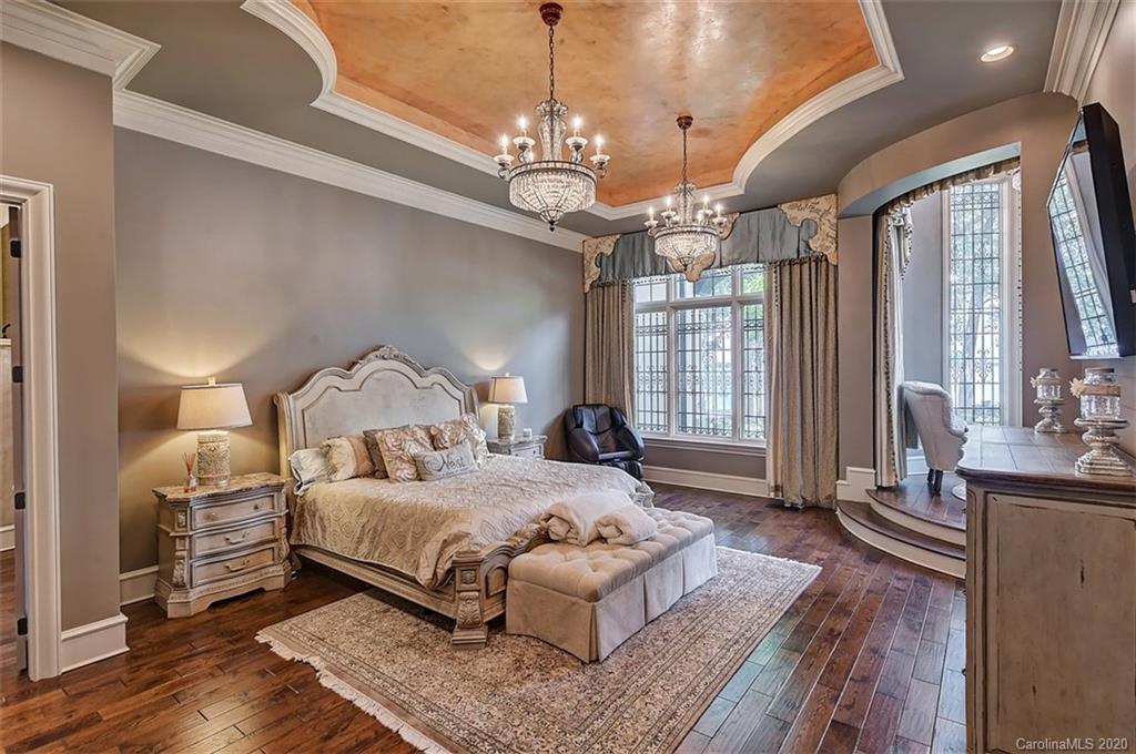 16505 Jetton Road Cornelius, NC 28031 - Photo 25 of 48 a spacious bedroom with a bed and a chandelier
