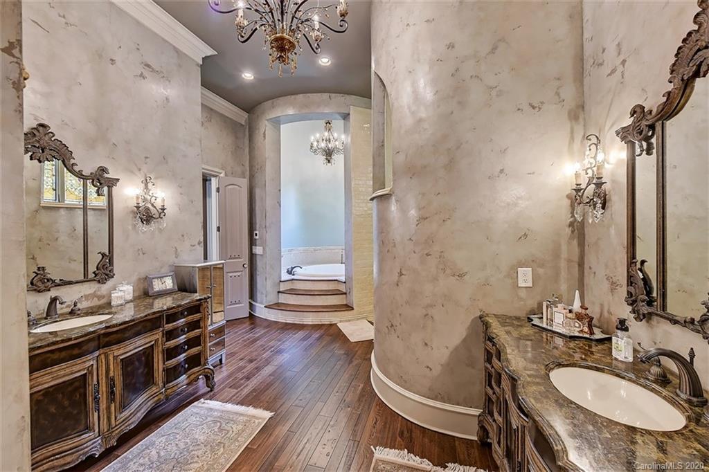 16505 Jetton Road Cornelius, NC 28031 - Photo 28 of 48 a bathroom with a granite countertop sink a toilet a mirror and shower