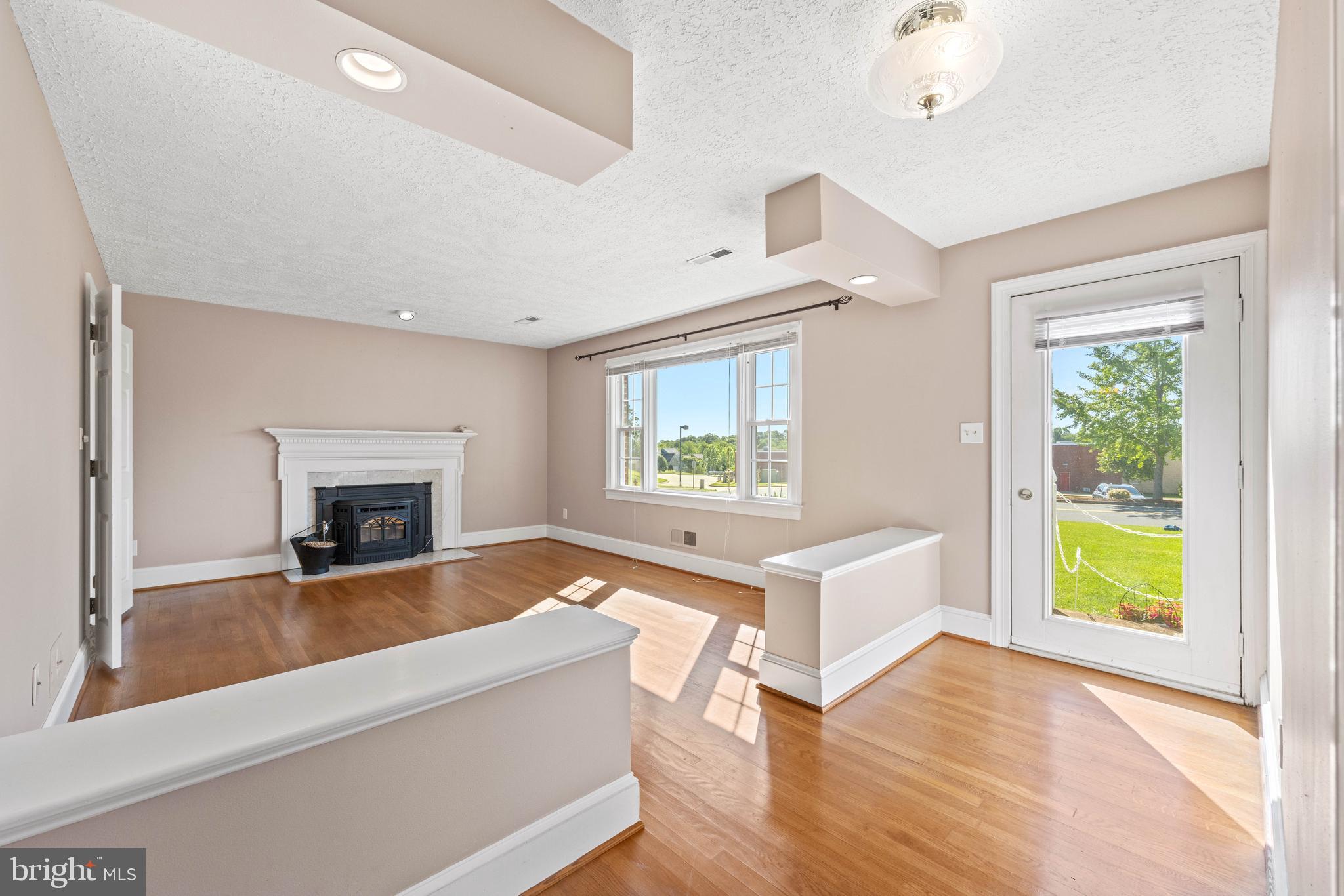 650 Yowell Drive Culpeper, VA 22701 - Photo 19 of 65 a living room with a fireplace windows and a wooden floor