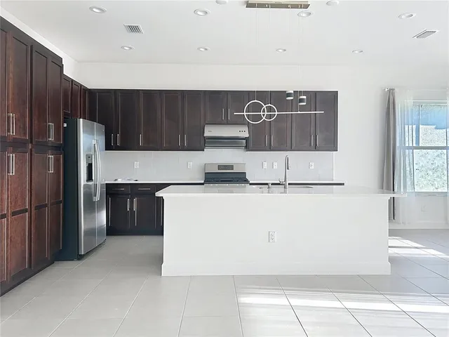 a kitchen with a cabinets and a refrigerator