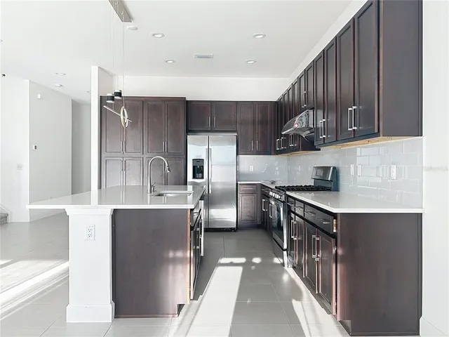a kitchen with stainless steel appliances granite countertop a sink stove and refrigerator