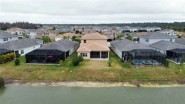 an aerial view of a house with a garden and lake view