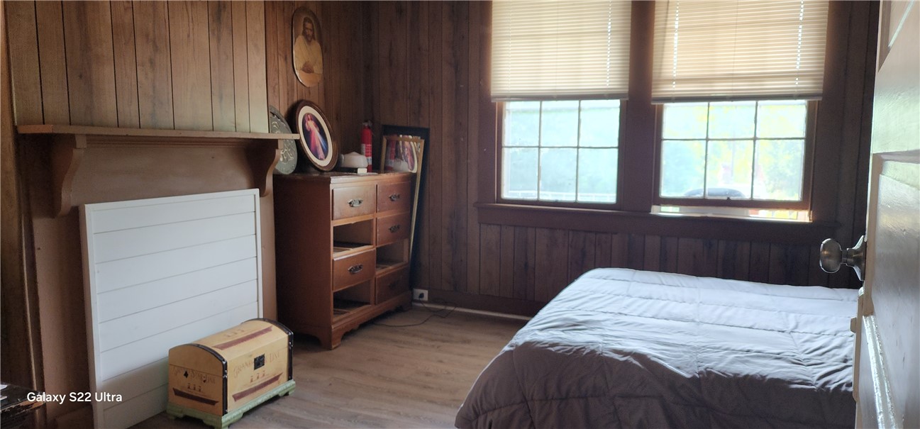 105 Hope Avenue Seneca, SC 29678 - Photo 14 of 33 A cozy bedroom with rich wood paneling and a large window offering ample daylight.