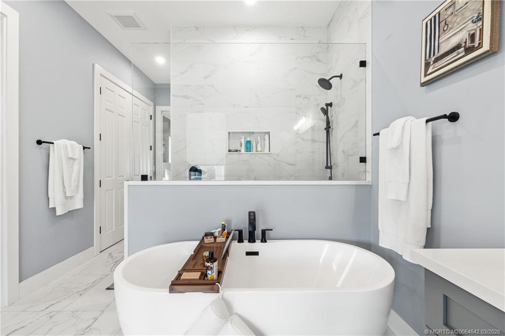 5169 Southeast Horseshoe Point Road Stuart, FL 34997 - Photo 22 of 54 a bathroom with a tub sink and mirror