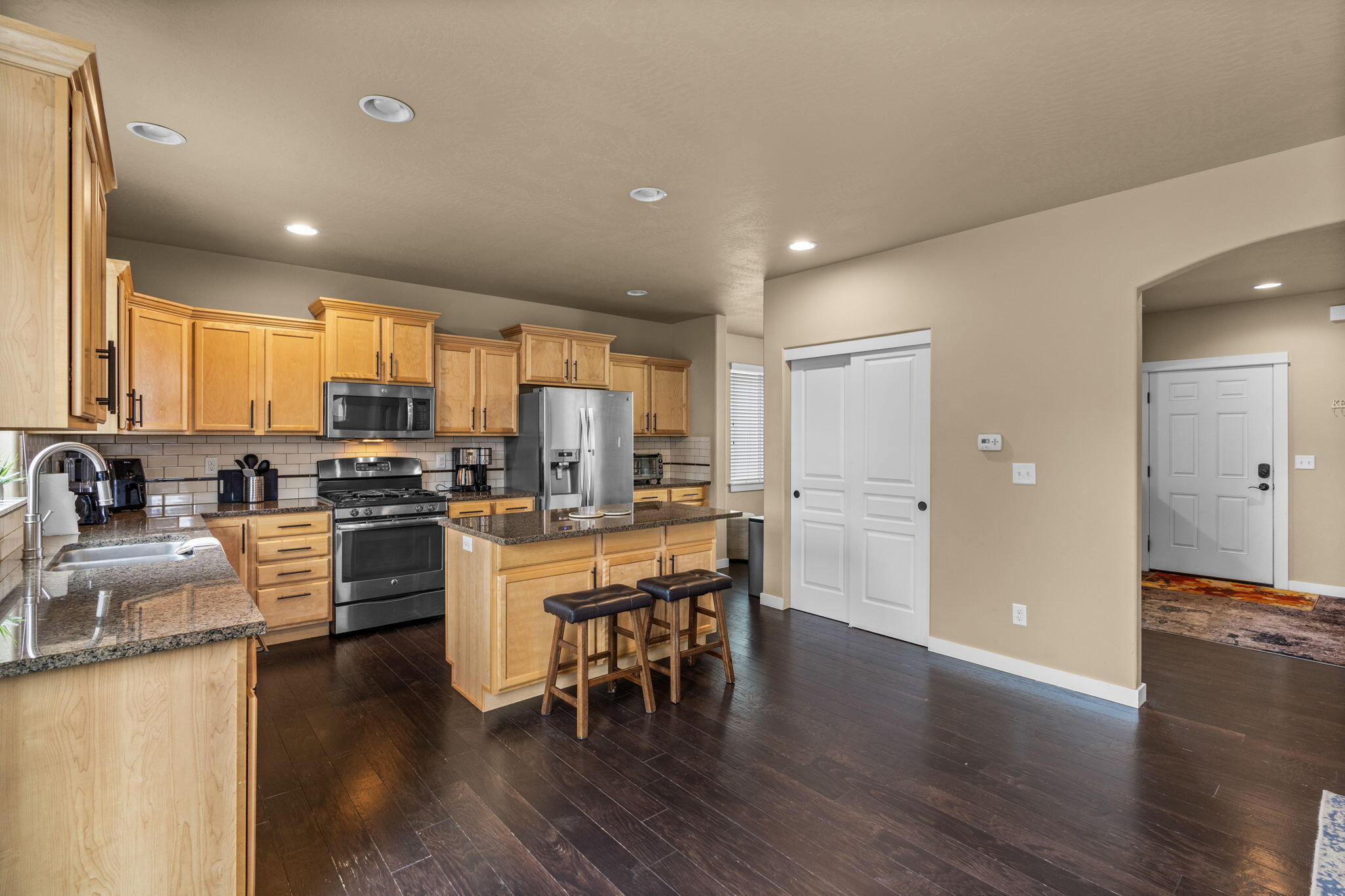 2781 Northeast Spring Water Place Bend, OR 97701 - Photo 5 of 23 a kitchen with stainless steel appliances granite countertop wooden cabinets a refrigerator a sink a stove a dining table and chairs
