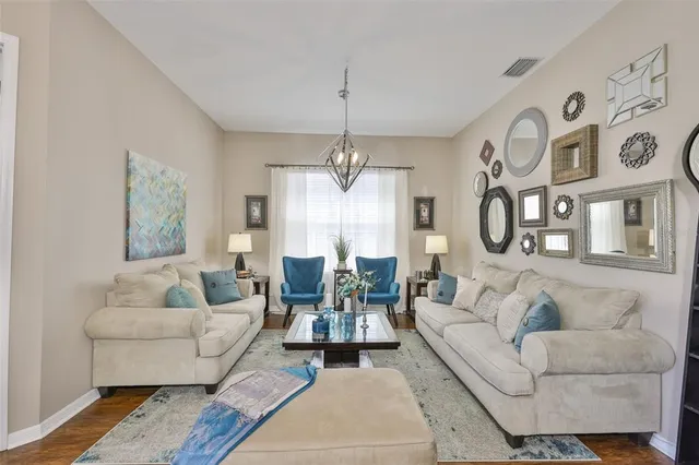 a living room with furniture and a chandelier