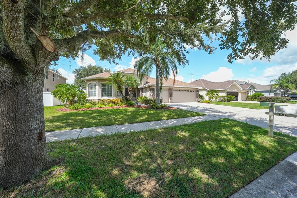 1204 Facet View Way Valrico, FL 33594 - Photo 45 of 59 a front view of a house with garden and trees